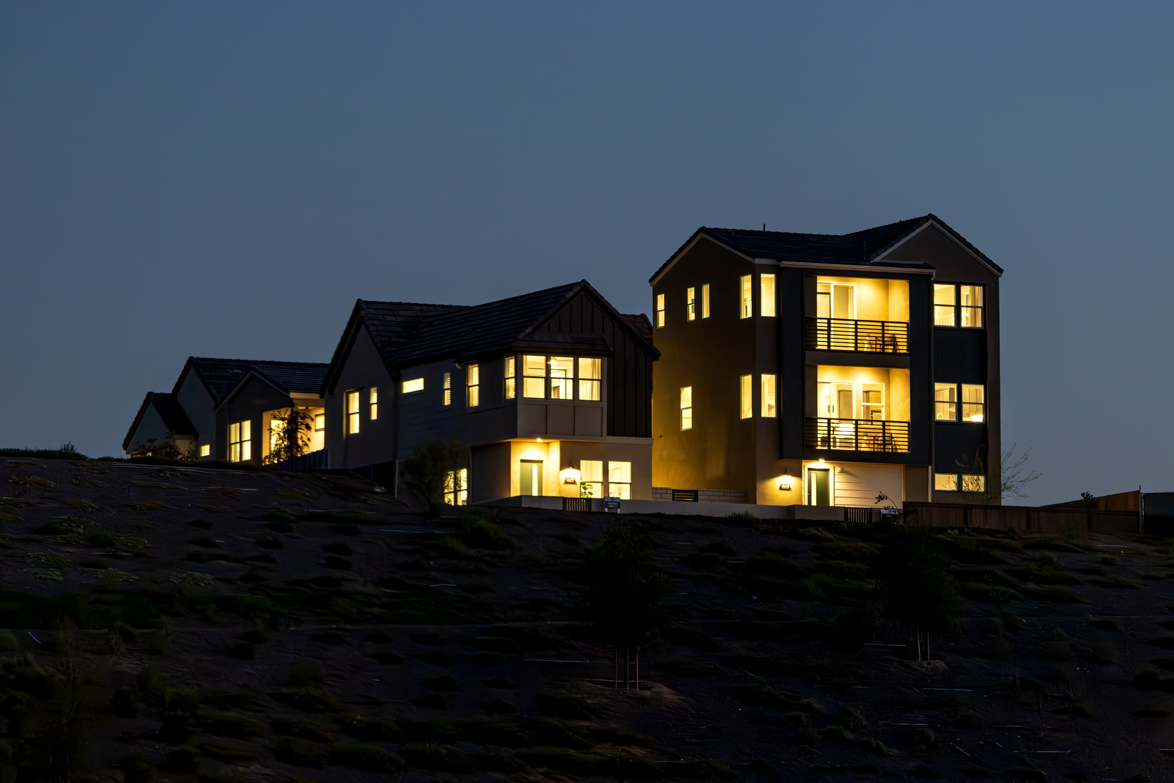 Casas contemporáneas iluminadas en una ladera al anochecer