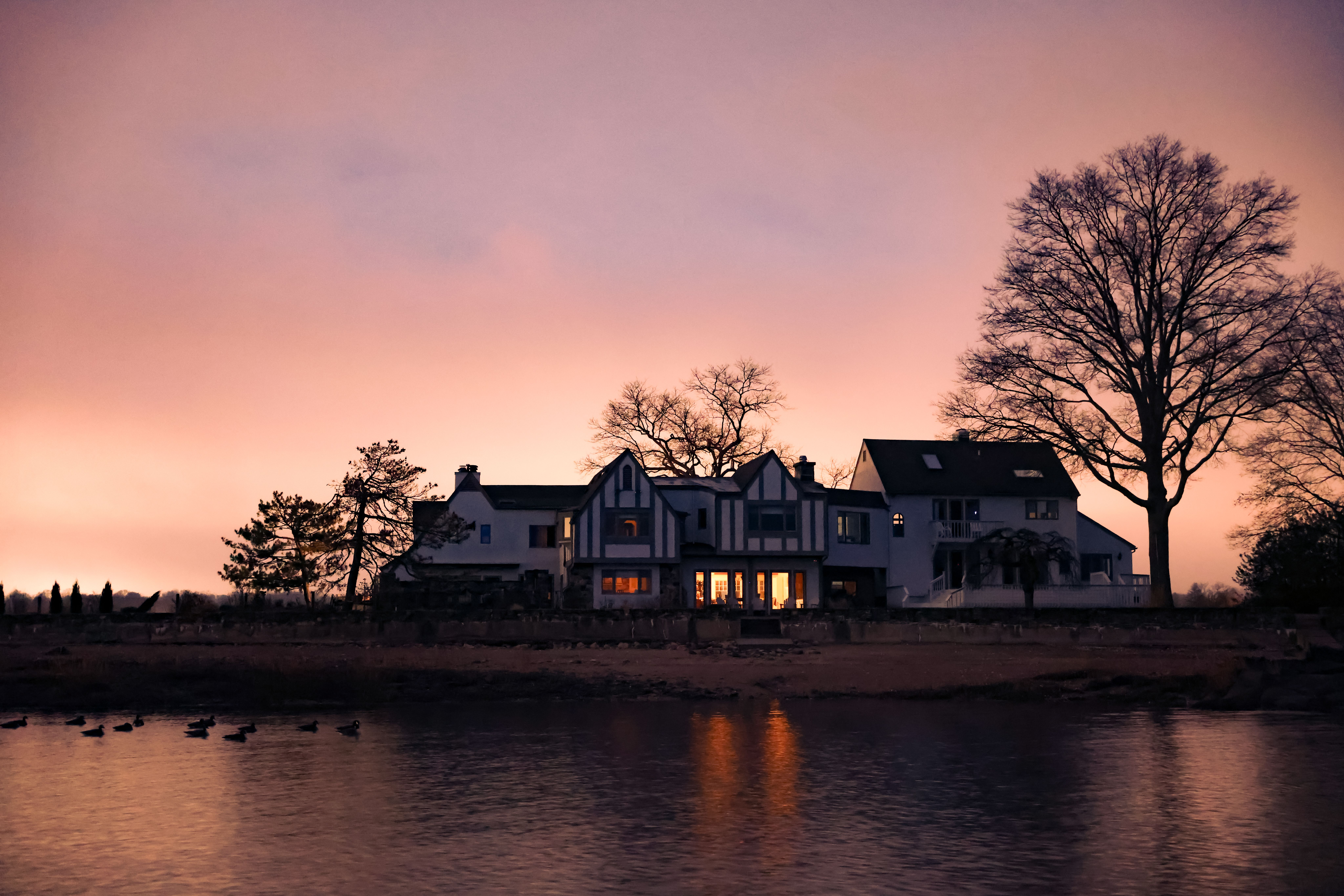 Casa junto al agua bajo el cielo del atardecer